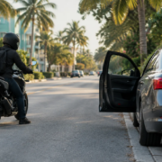 Miami motorcycle dooring accident scene with an open car door beside a motorcyclist